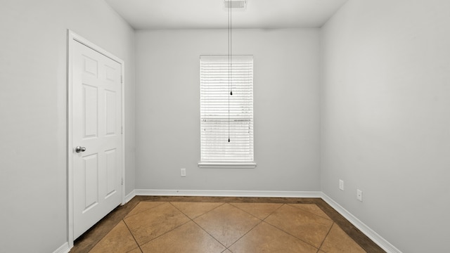 empty room with tile patterned flooring and a healthy amount of sunlight