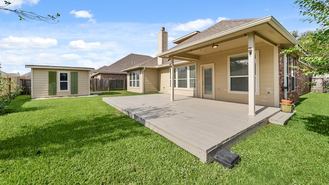 back of house with a storage shed, a wooden deck, and a lawn