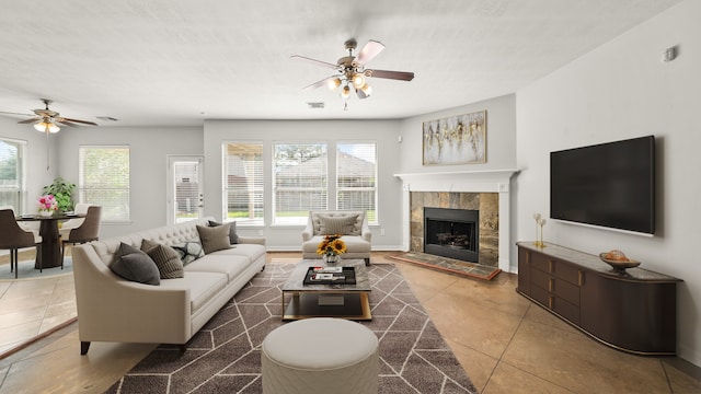 tiled living room featuring a fireplace and ceiling fan