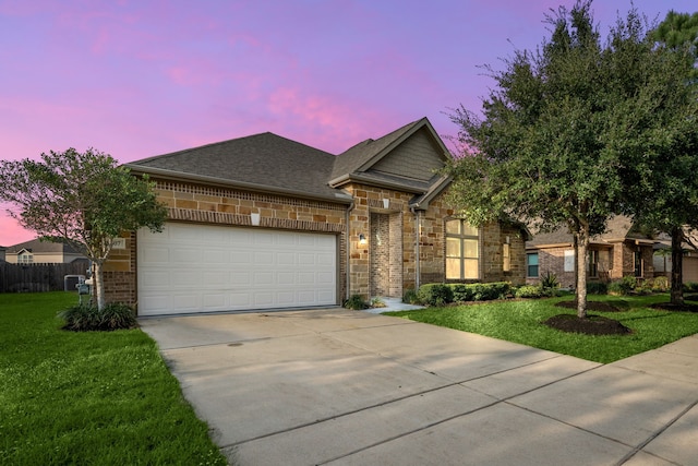 view of front of property with a garage and a yard