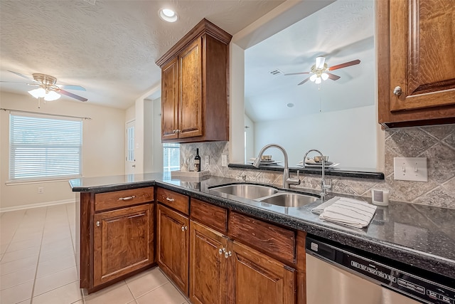 kitchen featuring backsplash, a textured ceiling, sink, stainless steel dishwasher, and kitchen peninsula