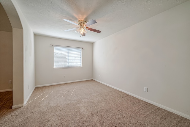 carpeted spare room with ceiling fan and a textured ceiling