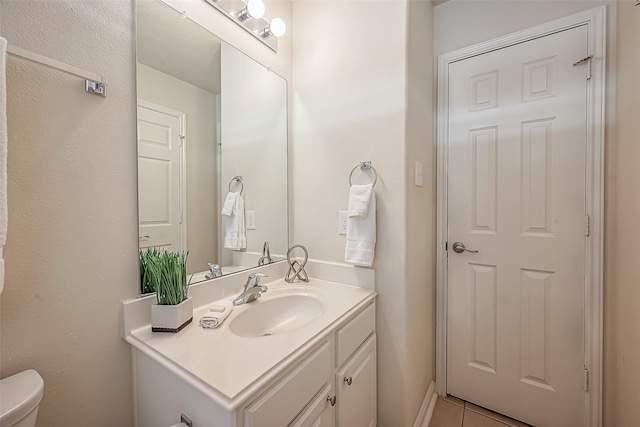 bathroom featuring tile patterned flooring, vanity, and toilet