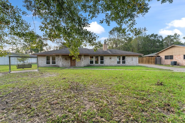 back of property featuring a lawn and central AC