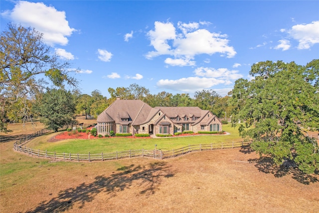 view of front of home featuring a front lawn and a rural view