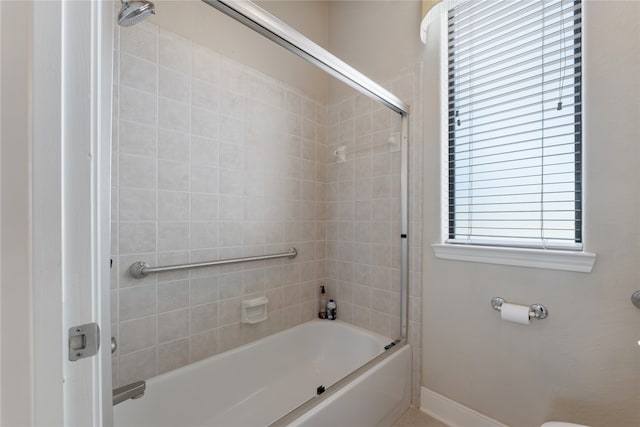 bathroom with toilet and tiled shower / bath combo