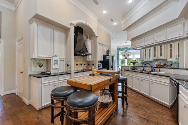 kitchen featuring dark hardwood / wood-style flooring, wall chimney exhaust hood, ornamental molding, and white cabinets