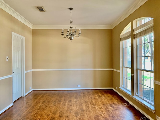 empty room with wood-type flooring, a healthy amount of sunlight, and crown molding