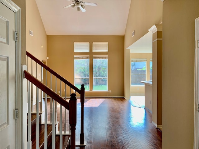 staircase with hardwood / wood-style flooring, ceiling fan, and high vaulted ceiling