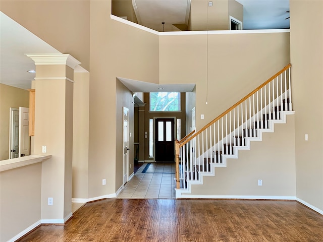 foyer with hardwood / wood-style flooring, a high ceiling, and beam ceiling