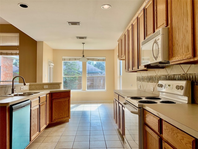 kitchen with light tile patterned flooring, backsplash, pendant lighting, sink, and white appliances