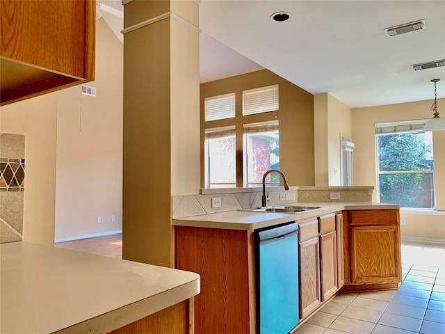 kitchen with kitchen peninsula, a wealth of natural light, and stainless steel dishwasher