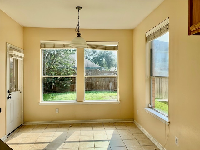 unfurnished dining area featuring light tile patterned flooring and plenty of natural light