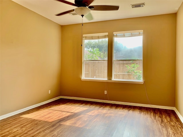 empty room with hardwood / wood-style floors and ceiling fan