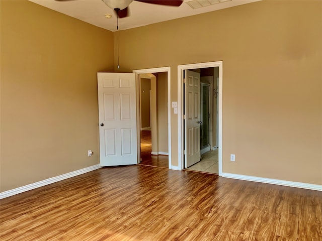 unfurnished bedroom featuring light hardwood / wood-style floors, ceiling fan, and ensuite bathroom