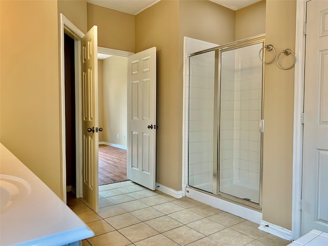 bathroom with an enclosed shower, vanity, and tile patterned floors