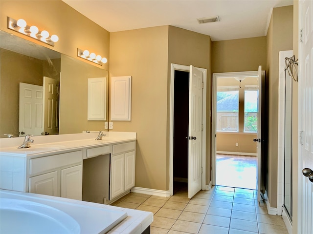 bathroom with vanity, tile patterned flooring, and a bath