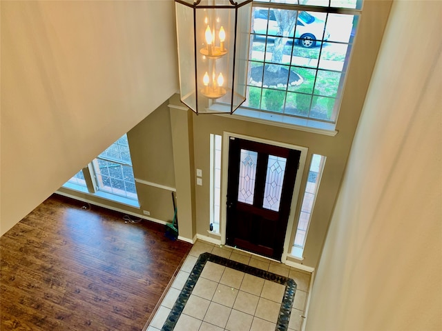 entrance foyer featuring dark tile patterned flooring, a high ceiling, and an inviting chandelier