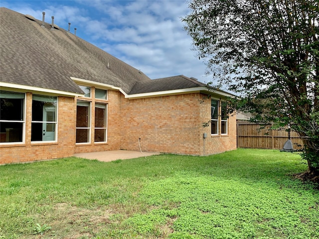 rear view of house featuring a patio and a yard