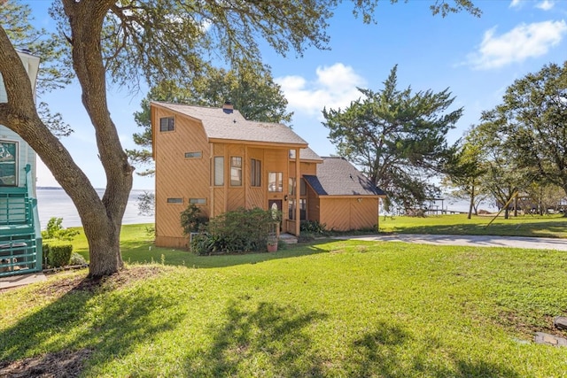 rear view of property featuring a lawn