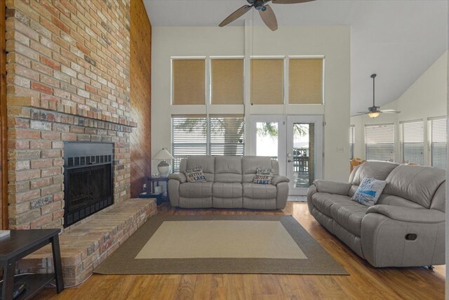 living room featuring hardwood / wood-style flooring, ceiling fan, and high vaulted ceiling