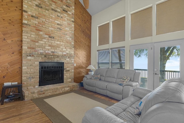 living room with wood-type flooring, a towering ceiling, and wooden walls