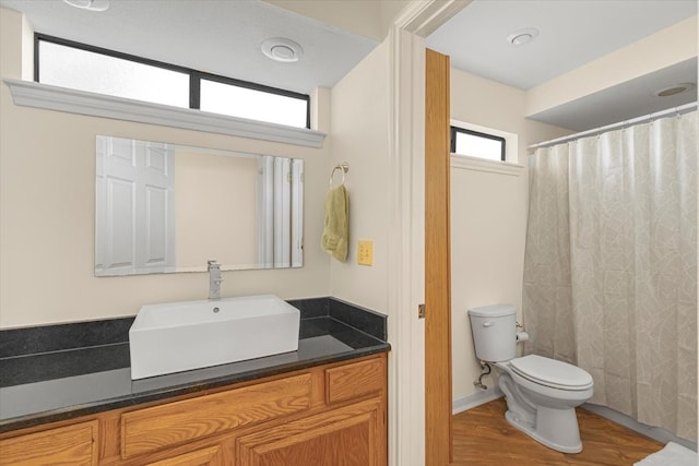 bathroom featuring vanity, hardwood / wood-style flooring, and toilet