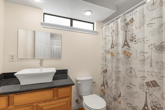 bathroom with vanity, toilet, and curtained shower