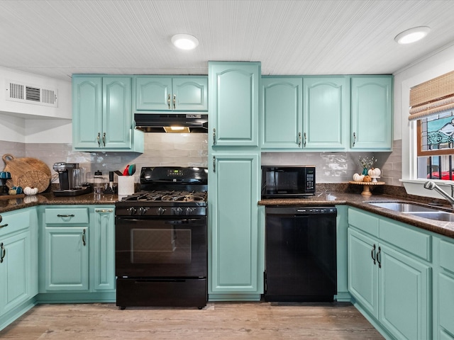 kitchen with sink, black appliances, green cabinetry, and light hardwood / wood-style floors