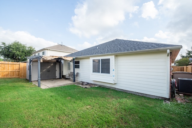 back of house featuring a lawn, cooling unit, and a patio area