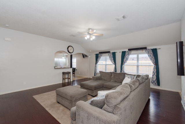 living room with dark wood-type flooring, ceiling fan, and vaulted ceiling