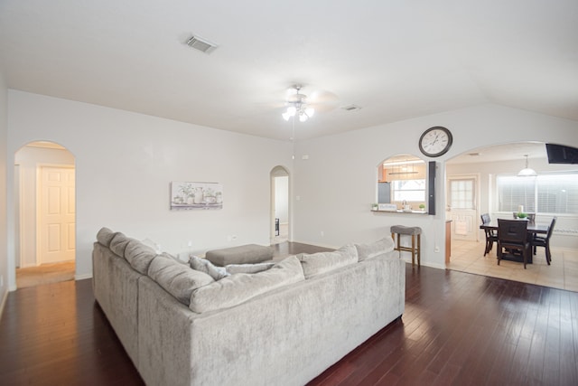 living room with dark wood-type flooring, ceiling fan, and lofted ceiling