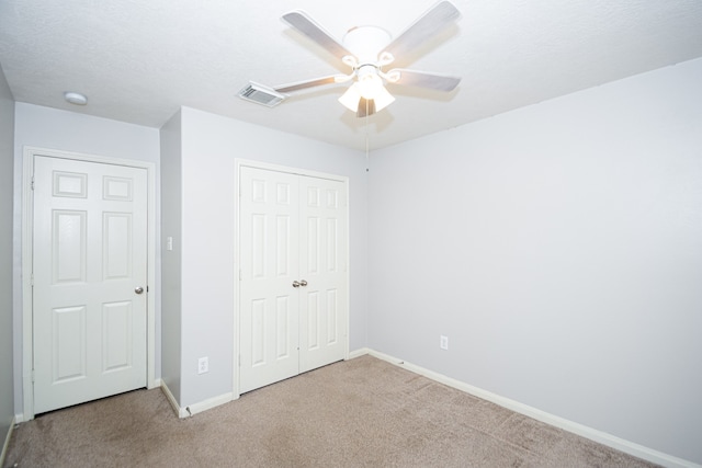 unfurnished bedroom with ceiling fan, light carpet, and a closet