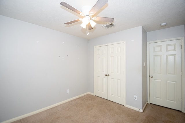 unfurnished bedroom with ceiling fan, a closet, and light colored carpet