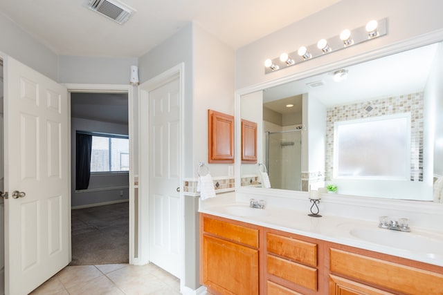 bathroom with walk in shower, vanity, and tile patterned floors