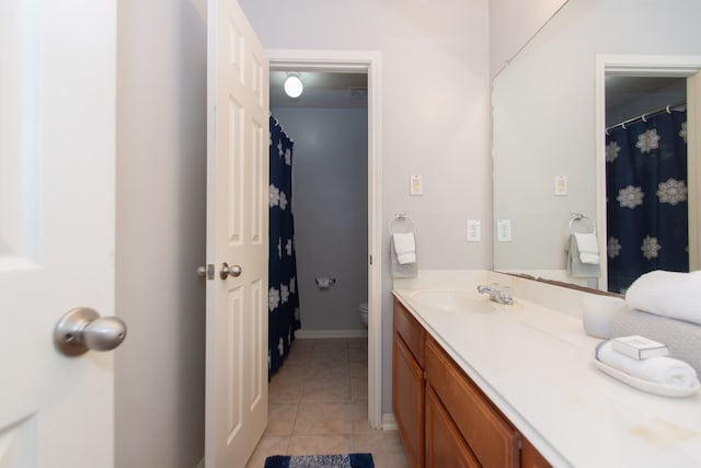 bathroom with toilet, vanity, and tile patterned floors