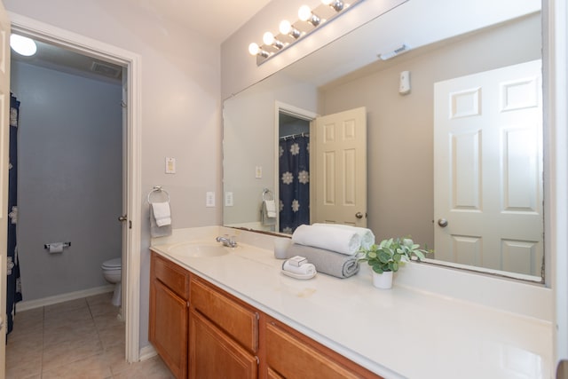 bathroom with toilet, vanity, and tile patterned floors