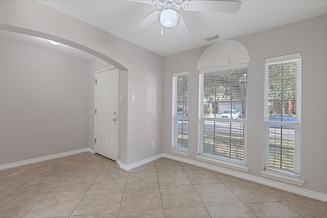 tiled empty room featuring ceiling fan