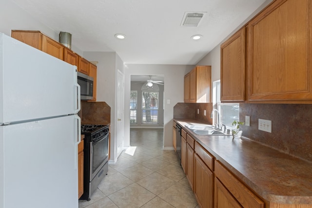 kitchen featuring black appliances, light tile patterned floors, sink, decorative backsplash, and ceiling fan