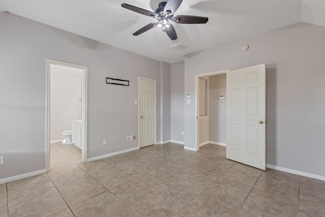 unfurnished bedroom with ceiling fan, ensuite bath, light tile patterned floors, and lofted ceiling