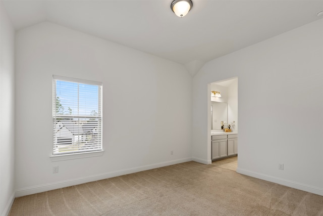 unfurnished room with light carpet and lofted ceiling