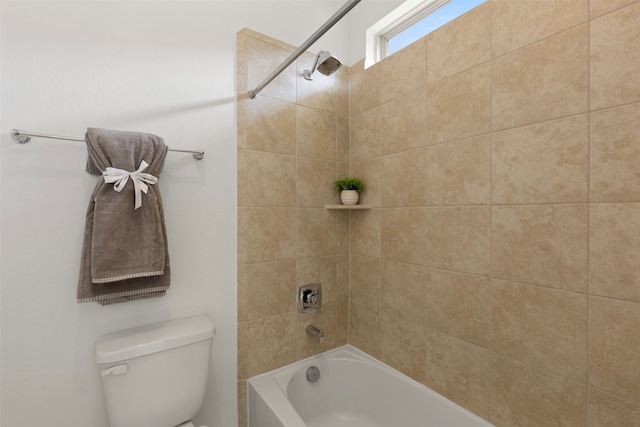 bathroom featuring toilet and tiled shower / bath