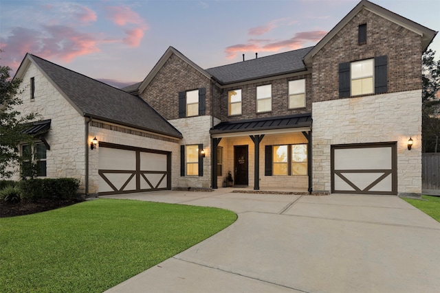 view of front of property with a garage and a lawn