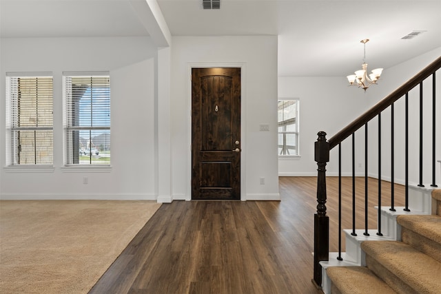 entrance foyer featuring a healthy amount of sunlight, wood-type flooring, and a chandelier