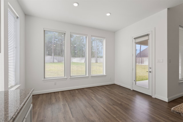 unfurnished dining area featuring dark wood-type flooring and a healthy amount of sunlight