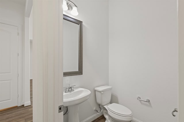 bathroom with hardwood / wood-style floors and toilet