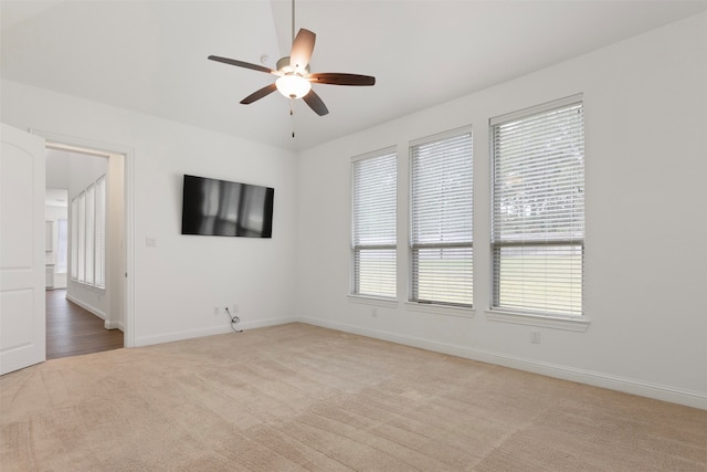 carpeted spare room with ceiling fan