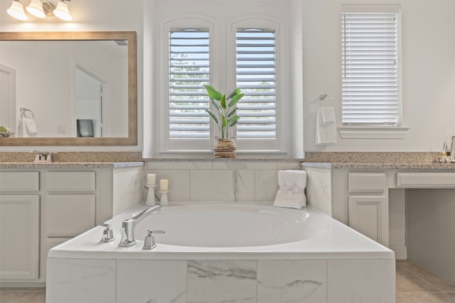 bathroom with vanity, a relaxing tiled tub, and tile patterned floors