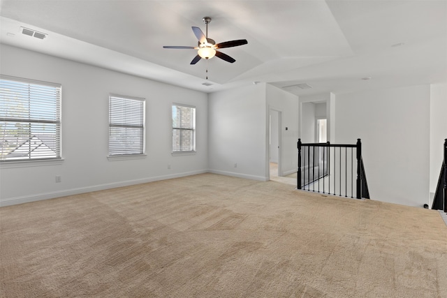 empty room with light colored carpet, a wealth of natural light, and vaulted ceiling