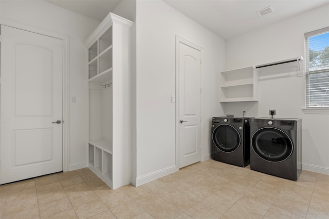 washroom with light tile patterned flooring and washing machine and clothes dryer